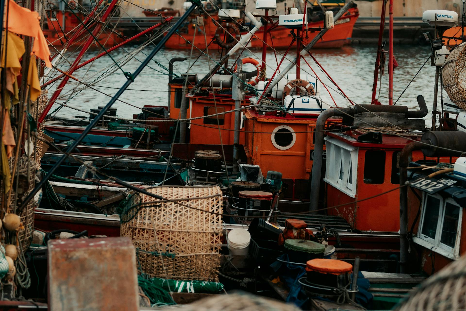 Close-up view of colorful fishing boats docked securely at a bustling harbor.