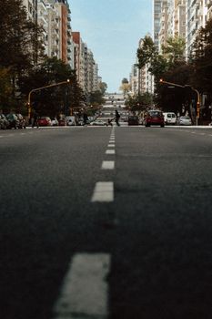 Street view in Mar del Plata with tall buildings and a distant pedestrian crossing.