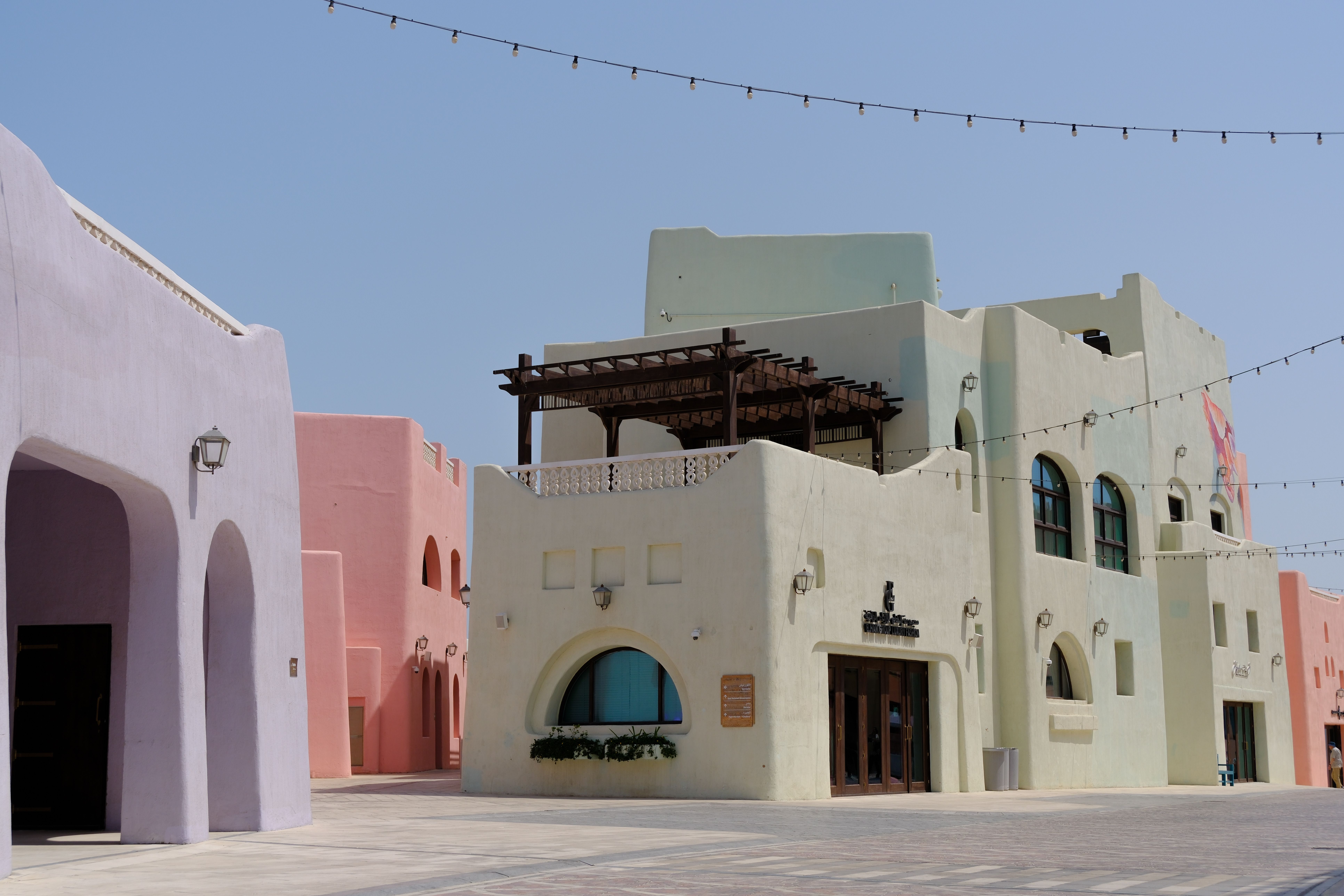 Encantadoras edificaciones en tonos pastel en Souq Al Wakra, Qatar, en un día soleado.