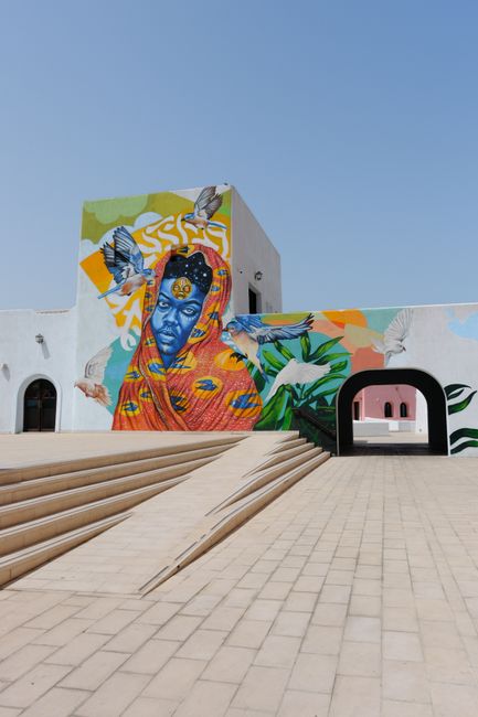 Vivid mural of a woman and birds on a contemporary building exterior.