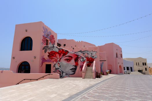 Vibrant street art mural on a pink building facade in Doha's Katara Cultural Village, showcasing contemporary art.