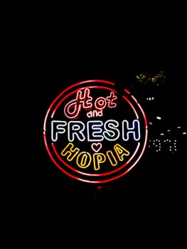 Colorful neon sign of 'Hot and Fresh Hopia' on dark background, perfect for urban design themes.