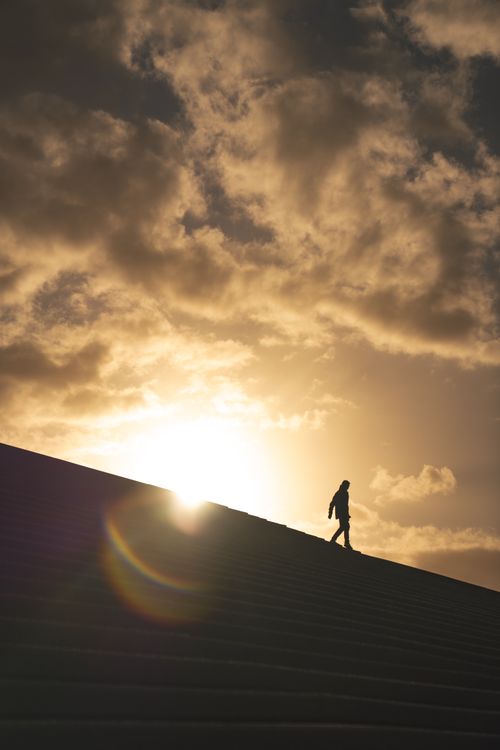 Free A lone silhouette on Sydney skyline at sunrise, capturing a tranquil moment against a dramatic sky. Stock Photo