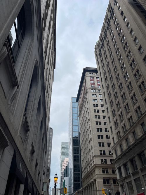 Free A dynamic urban street view featuring historic and modern architecture reaching into an overcast sky. Stock Photo