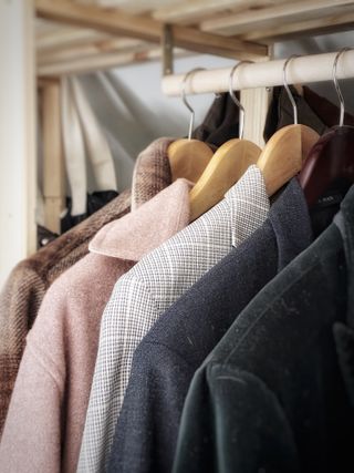 Black wool coat on a hanger — photo by Luk Sauvage on Pexels
