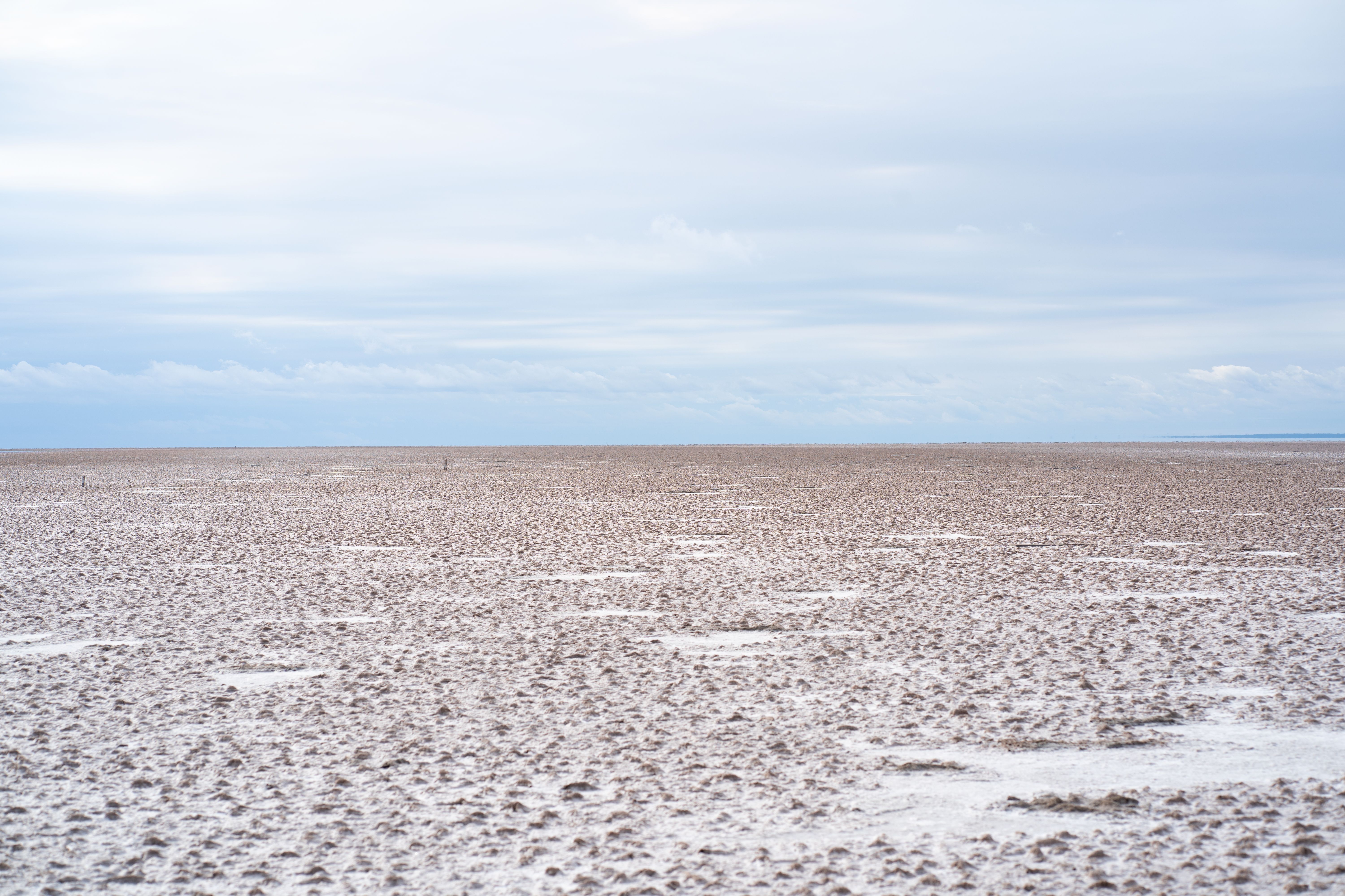 Wide expanse of salt flats beneath a cloudy sky at San José de Las Salinas, Córdoba, Argentina.