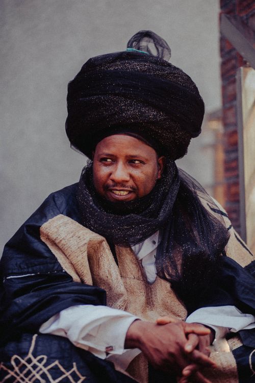 Free Portrait of a man in traditional African attire and turban, looking thoughtful. Stock Photo