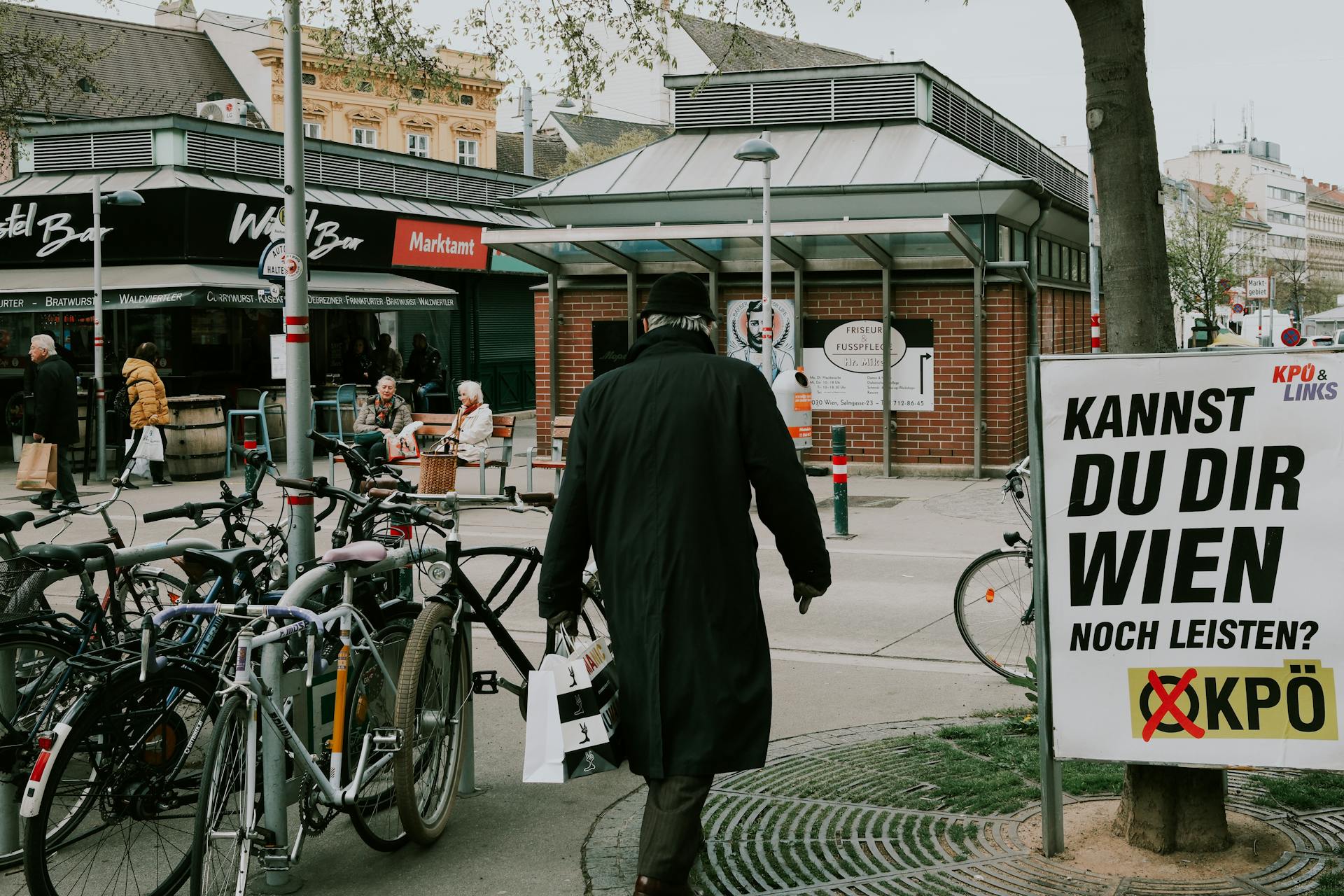 Urban street scene in Vienna featuring a bicycle rack and people walking.