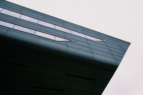 Free Close-up view of a modern building's exterior with geometric lines and glass windows. Stock Photo