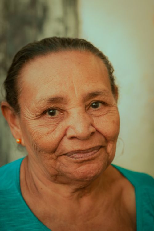 Free A close-up portrait of a senior woman with a warm smile indoors. Stock Photo