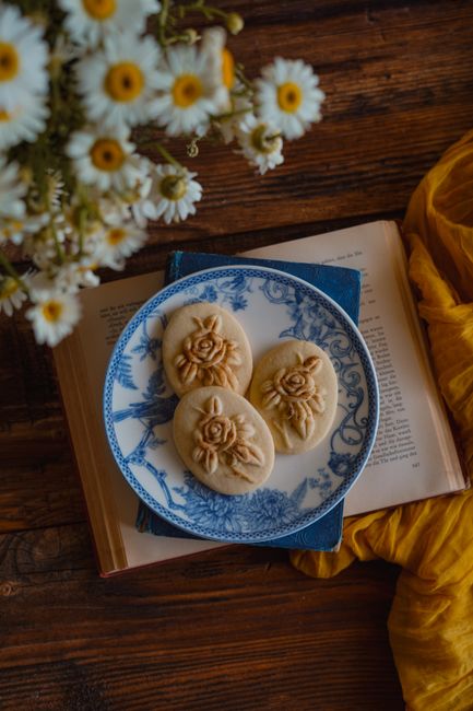 Artistic presentation of floral embossed cookies on a vintage plate with a rustic setting.