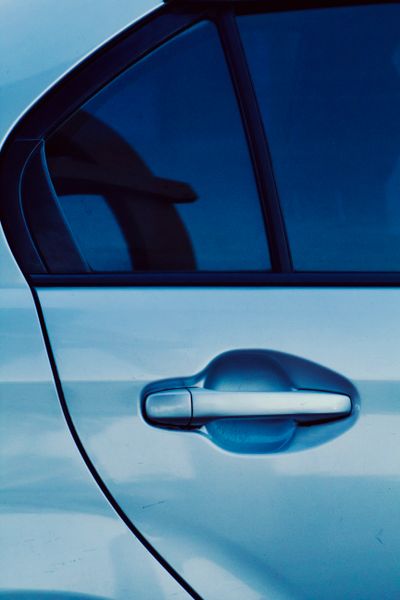 Close-up of car door with blue tinted window film