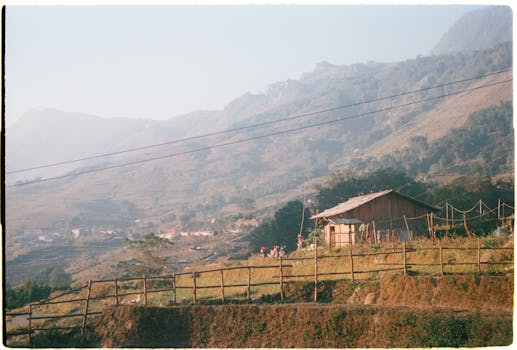 Captivating rural landscape in Lao Cai, Vietnam, featuring mountain backdrop and traditional village.