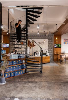 A sleek, contemporary coffee shop in Yunnan, China, featuring a spiral staircase and warm ambiance.