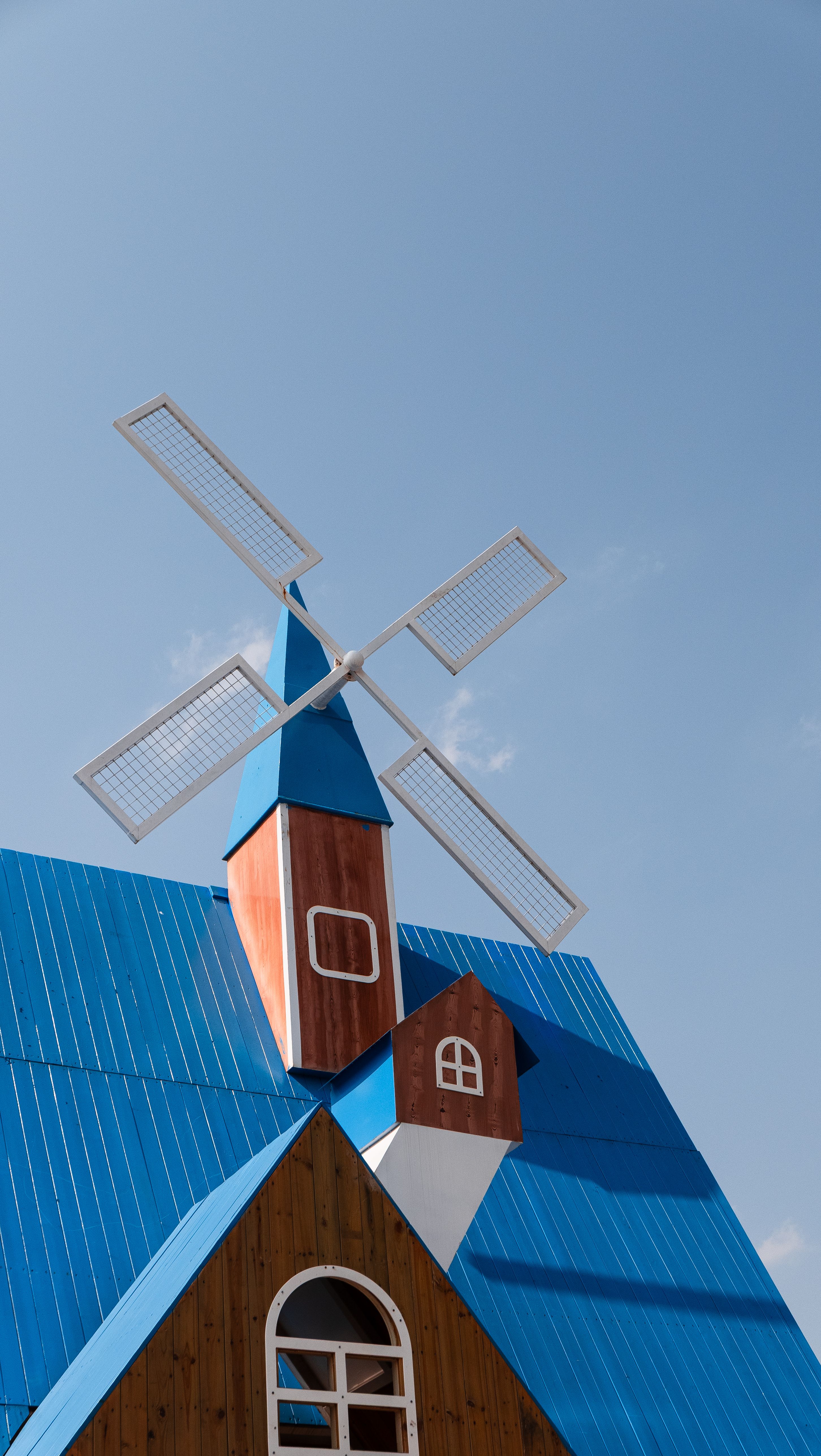 Charming Blue Roof Windmill Against Clear Sky · Free Stock Photo
