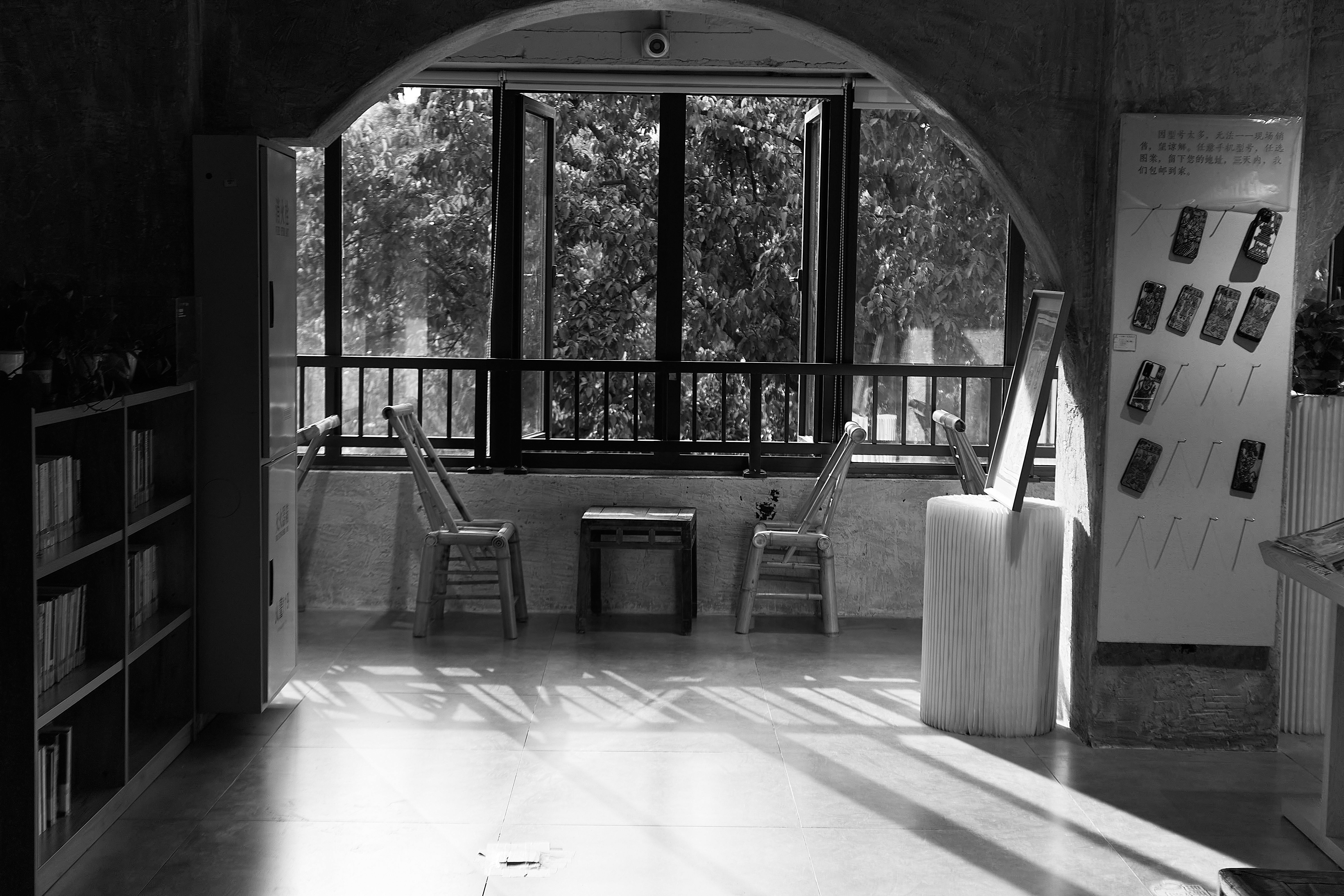 Free Black and white photo of a tranquil indoor reading area with chairs facing an open window. Stock Photo