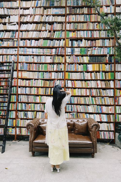 Woman exploring a vast library book collection
