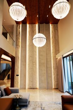 Spacious, modern living room featuring striking pendant chandeliers, elegant decor, and high ceilings.. pexels, spacious, mod