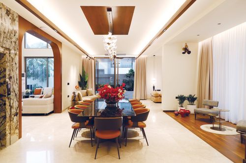 Free Elegant and spacious modern dining room with a glass table, stylish chairs, and decorative lighting. Stock Photo