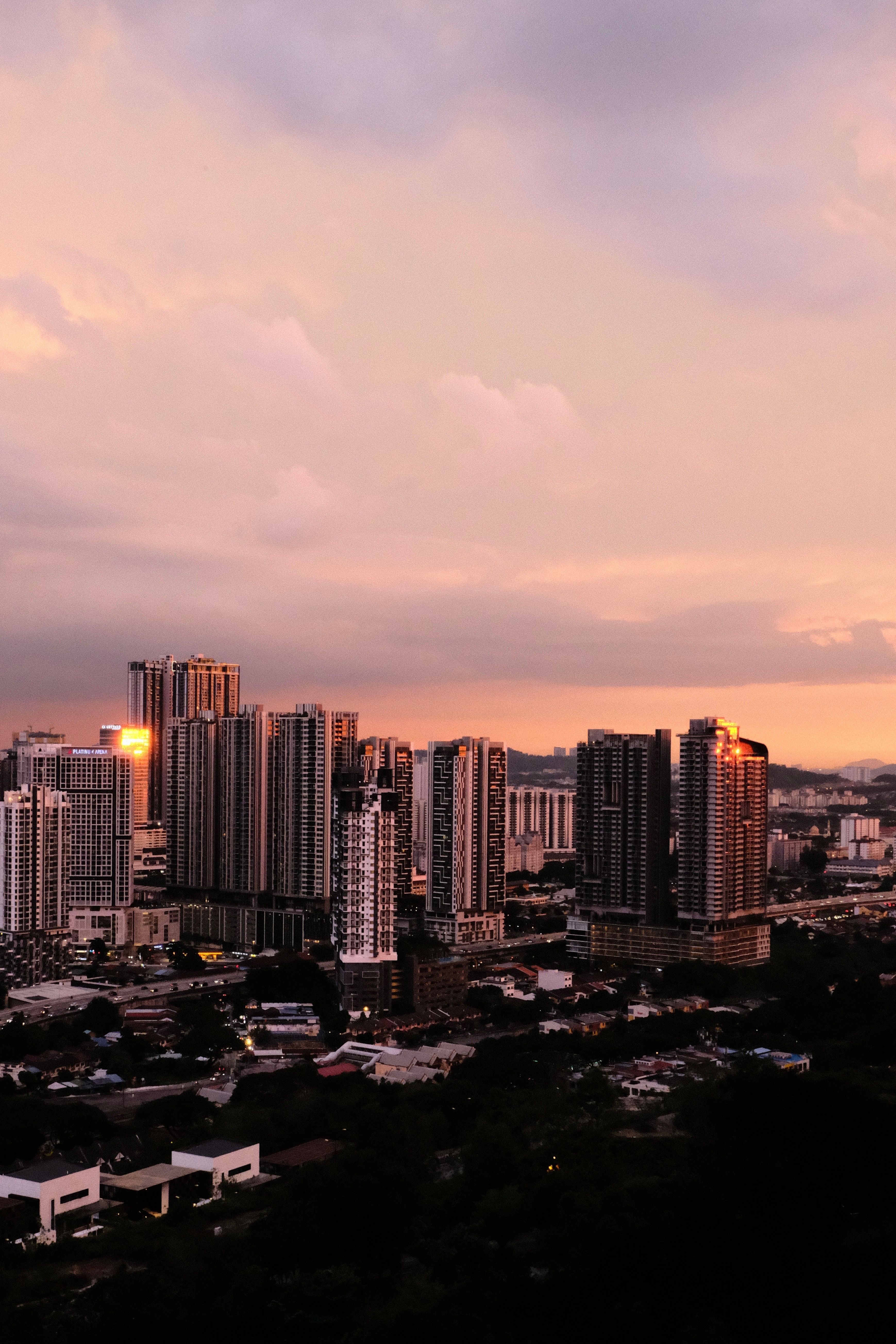 Condominium towers across Kuala Lumpur under a pink sunset sky