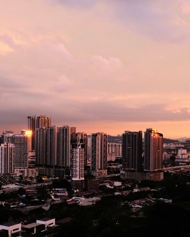 Condominium towers across Kuala Lumpur under a pink sunset sky
