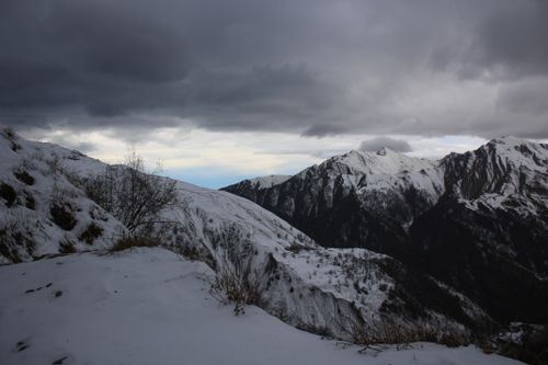 Free Snowy mountain landscape under dark stormy skies, creating a dramatic scenery. Stock Photo