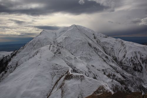 Free Majestic snowy mountain peak with dramatic cloudy sky, showcasing winter's beauty Stock Photo