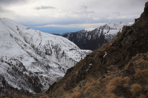 Free Breathtaking view of snow-capped mountains under a cloudy sky, showcasing rugged terrain. Stock Photo
