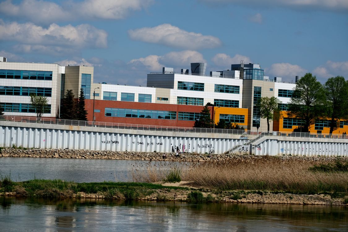 Modern Building by Riverside on Sunny Day · Free Stock Photo