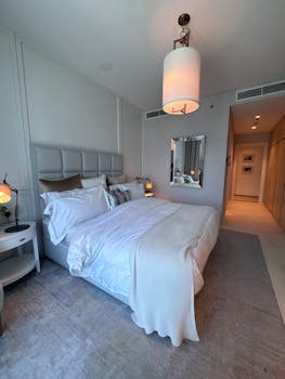 Elegantly decorated modern bedroom with luxurious bedding and soft lighting.