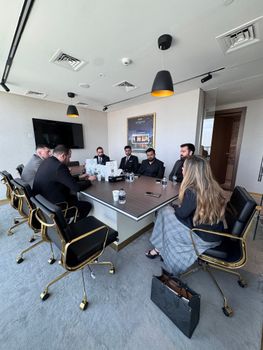 Corporate executives engaged in a meeting in a stylish conference room with modern decor.