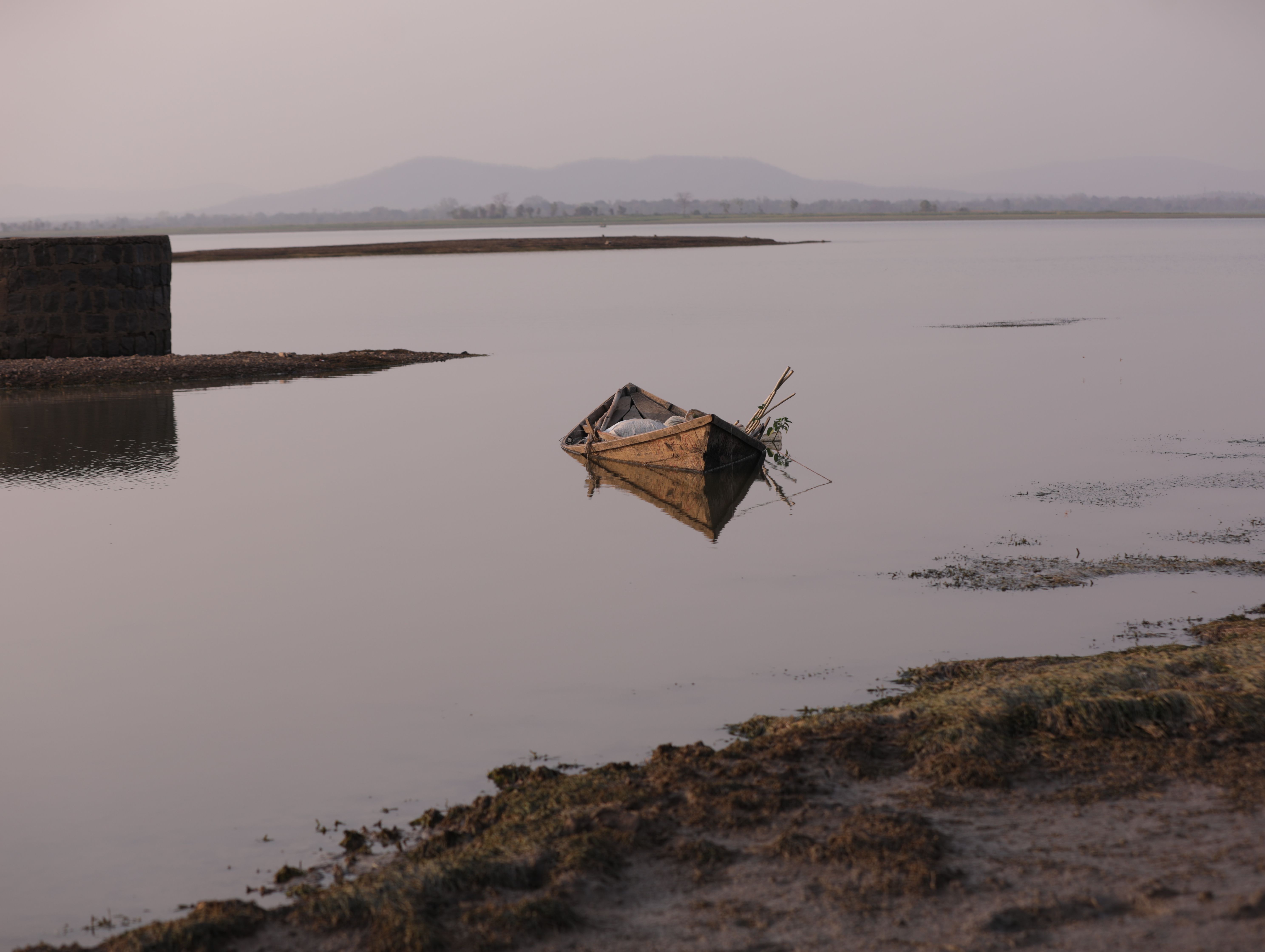 Boats and Aravalli hills reflected in Damdama Lake near Sohna