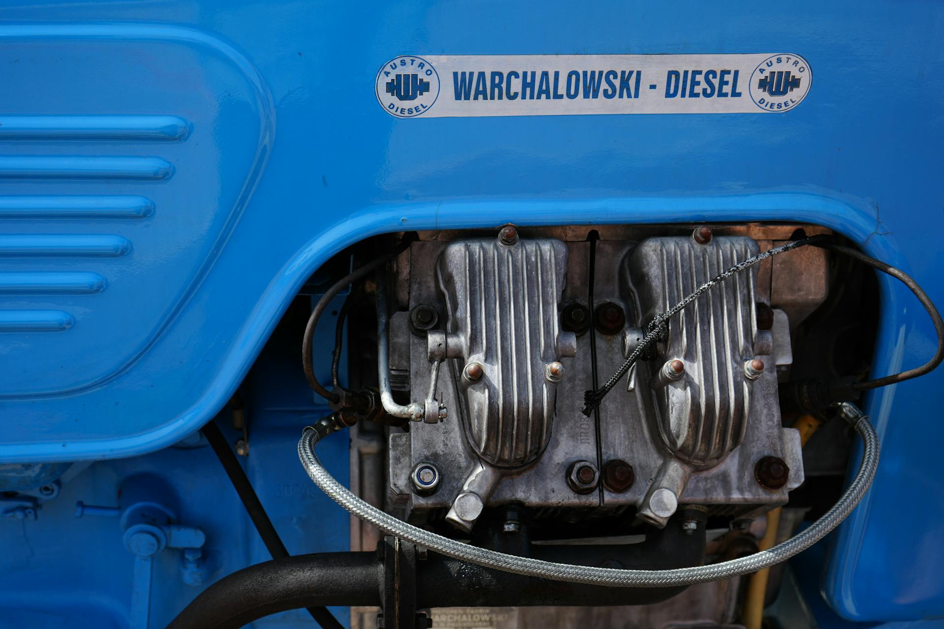 Detailed view of a Warchalowski diesel engine with visible components and vibrant blue cover.