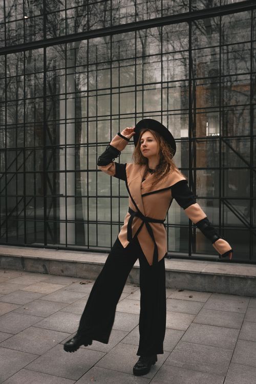 Free Fashionable woman posing in autumn attire against a modern glass backdrop. Stock Photo