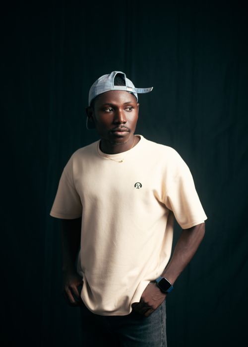 Free Man in casual clothing with cap and watch, dark background. Stock Photo