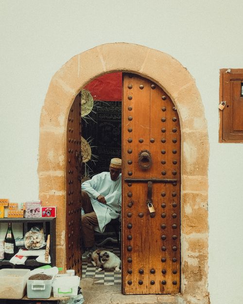 Free A candid moment at a traditional doorway in Rabat, Morocco, showcasing urban street life. Stock Photo