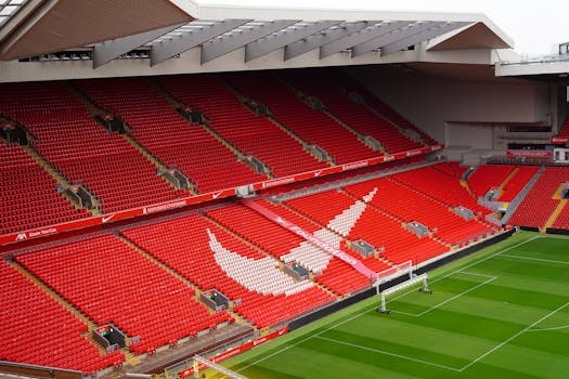 Aerial view of Anfield Stadium's iconic red seats and pitch, showcasing its architecture and design.