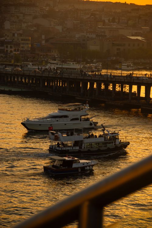 Free Evening view of boats on the Bosporus under a golden sunset in İstanbul, Türkiye. Stock Photo