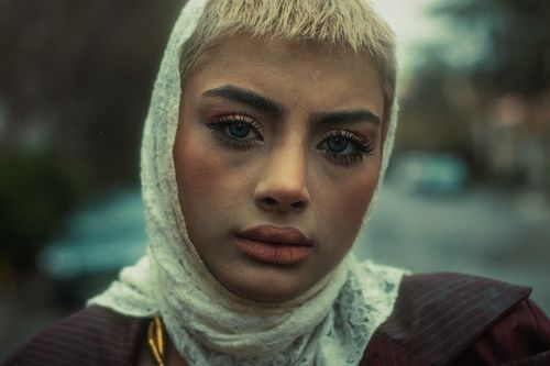 Free Close-up portrait of a young woman with a headscarf, creating a dramatic mood. Stock Photo