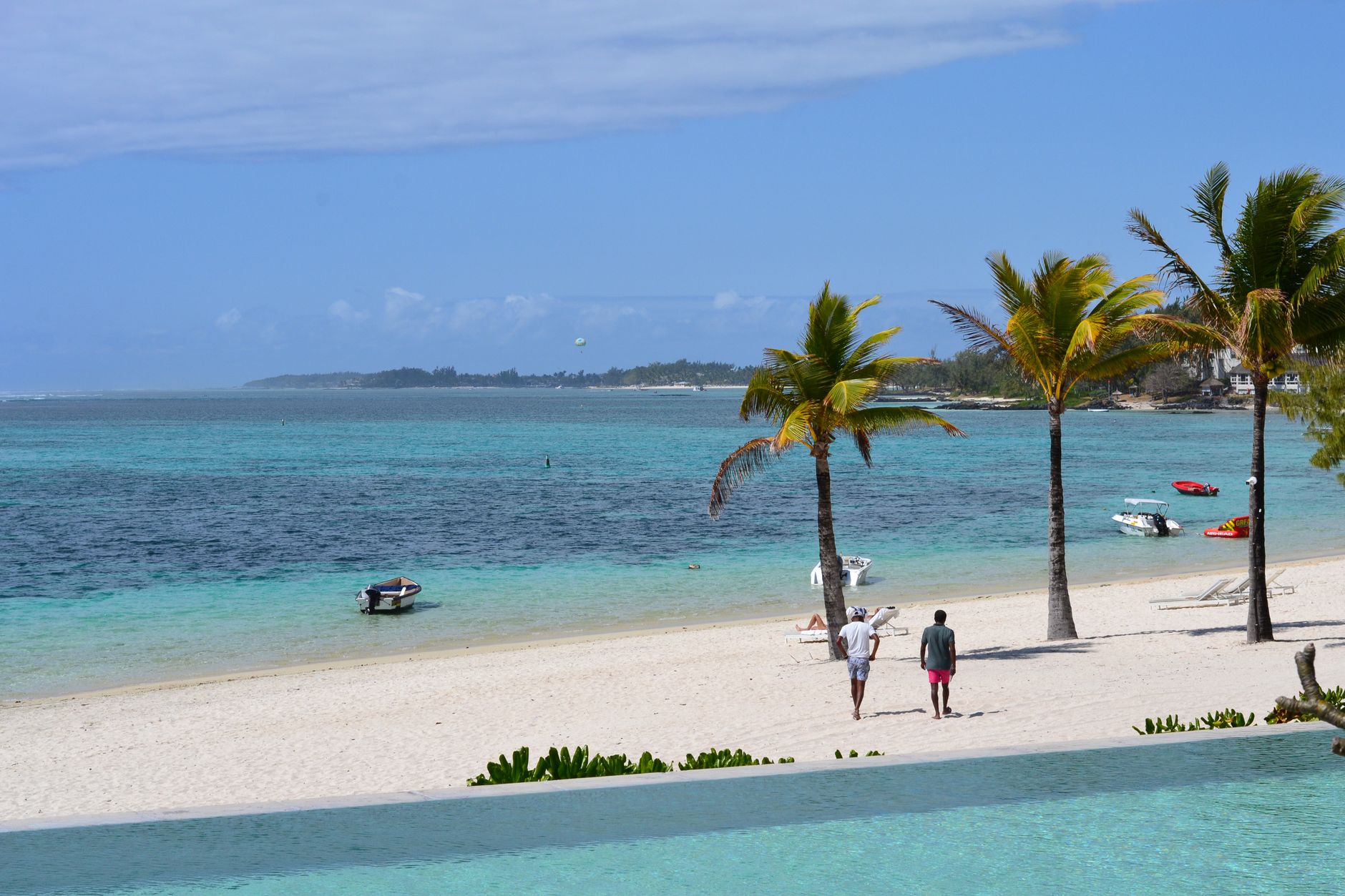 Relaxing tropical beach scene with palms and turquoise waters in Mauritius.