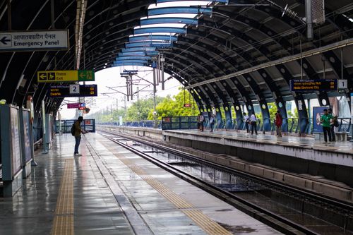 Free People waiting at a lively New Delhi metro station platform during a rainy day. Stock Photo