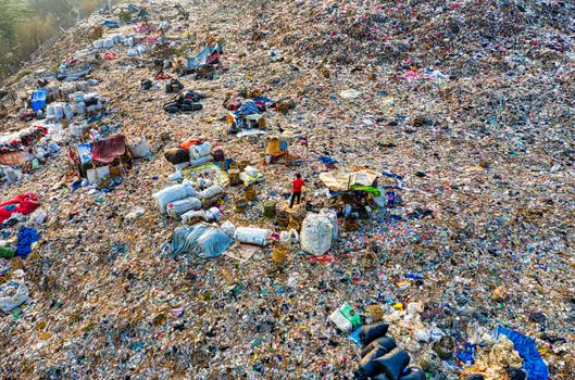 An aerial shot of a landfill site with scattered trash and environmental damage.
