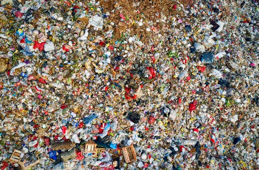Vibrant and chaotic aerial view of a large urban landfill, characterized by mixed garbage.