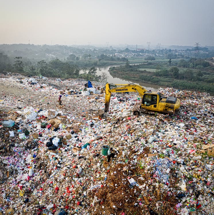 Yellow Excavator on Piles of Trash