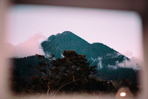 Free Capture of a lush mountain peak surrounded by mist against a gentle evening sky in the Philippines. Stock Photo