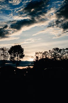 A captivating sunset with silhouette trees and dramatic clouds in the Philippines.