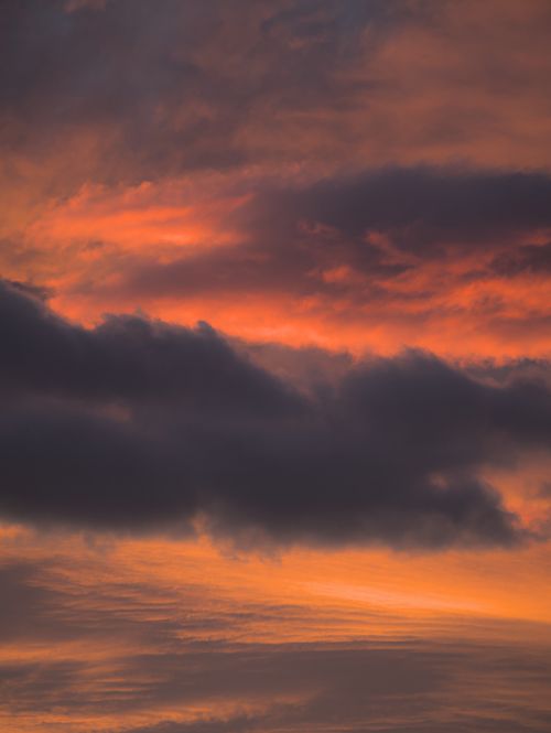 Free Vibrant orange and dark clouds during a stunning sunset sky. Stock Photo
