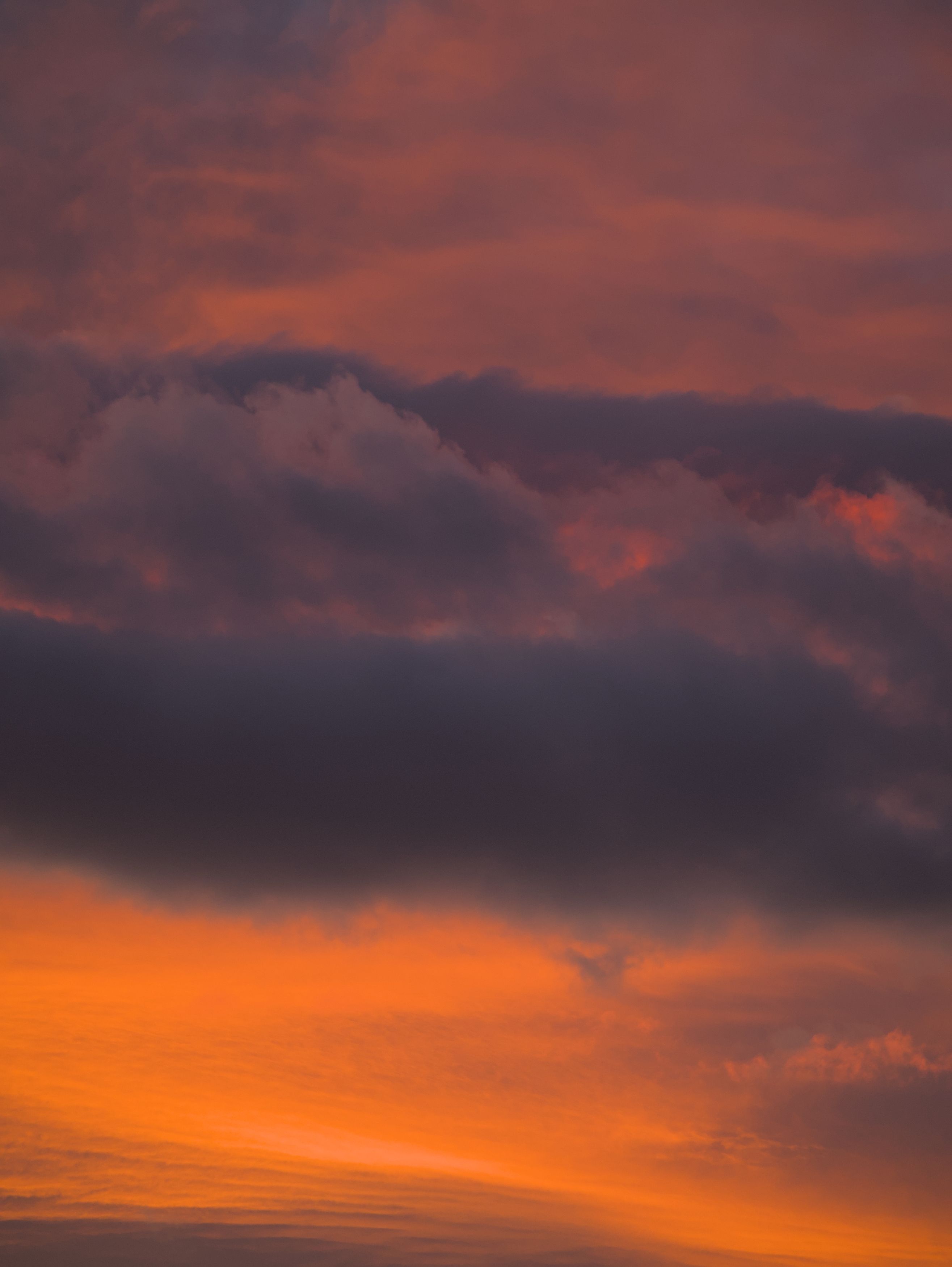 De franc Una posta de sol taronja vibrant amb núvols foscos creant un efecte de cel espectacular. Foto d'estoc