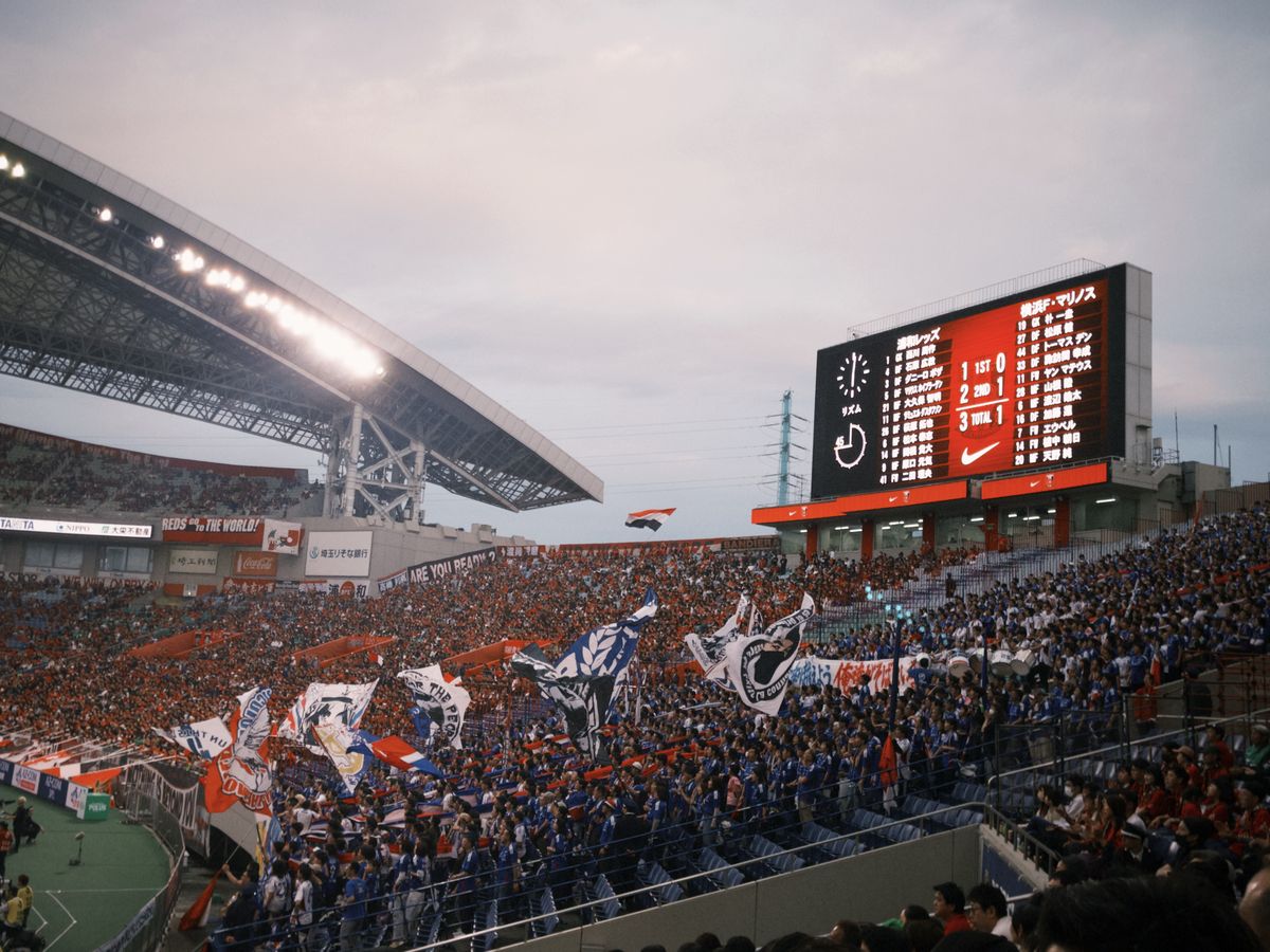 A packed soccer stadium full of fans waving flags