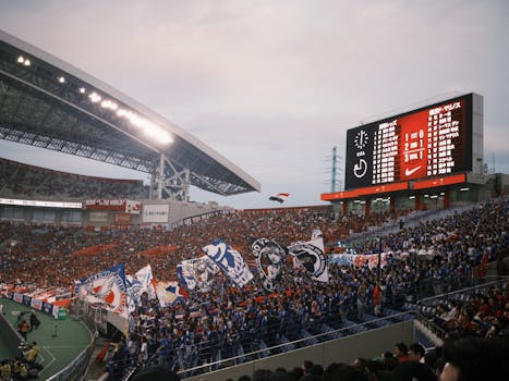 Energetic soccer match scene with cheering crowd and colorful flags in a large stadium.